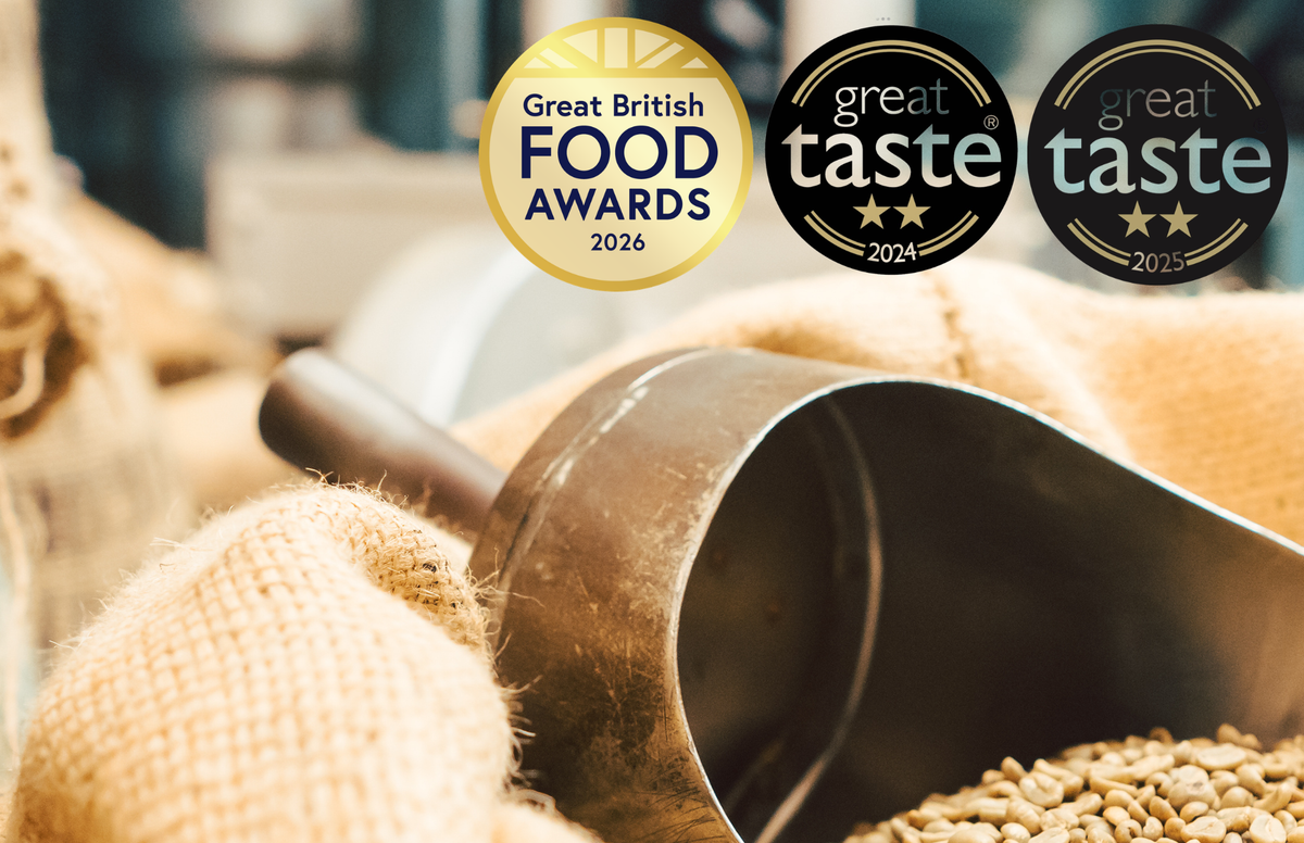 Acorns coffee award winning coffee roastery in bordon. Image of green bean coffee and coffee roastery in background with 4 time award winning coffee
