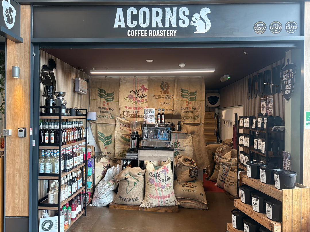 shop front of acorns coffee roastery showing bagged coffee beans, hessian coffee sacks with raw green coffee and coffee syups