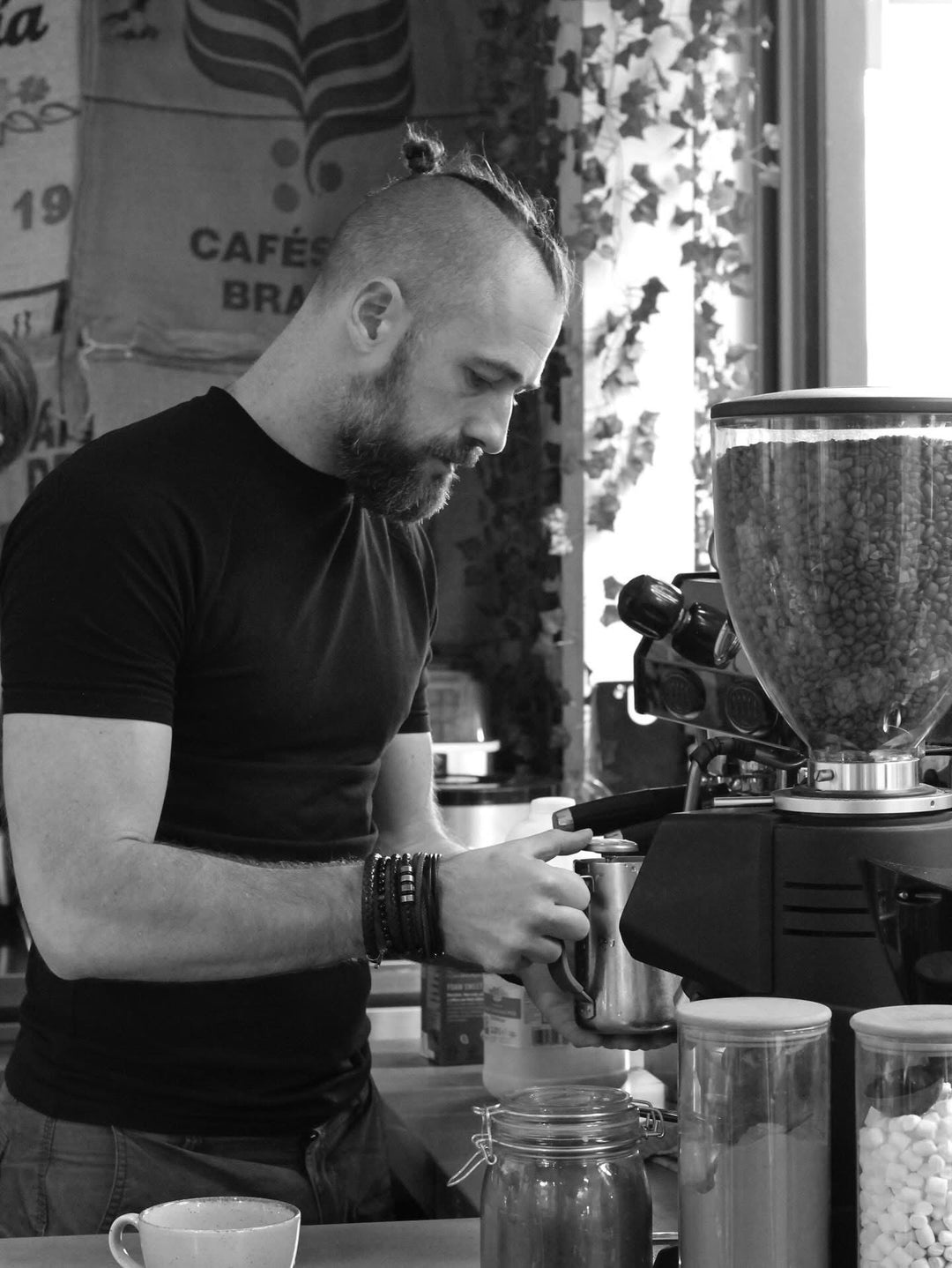 Man operating a coffee machine in a cafe setting